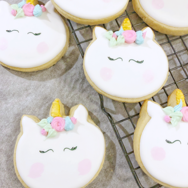Image of hand-painted unicorn vanilla sugar cookies sitting on a cooling rack